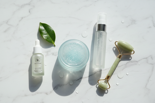 Lightweight Korean skincare products — gel moisturizer, toner mist, and niacinamide serum on white marble with a jade roller — glass skin routine for oily skin